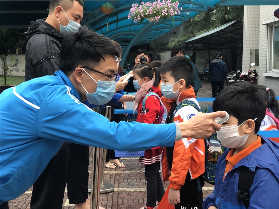 Trong ngày đầu tiên trở lại trường, học sinh trên địa bàn TP Hà Nội được yêu cầu đeo khẩu trang, đo thân nhiệt và giữ khoảng cách khi xếp hàng vào trường.