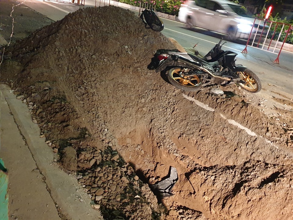 Xe máy của nạn nhân bay lên đống cát mới đào múc trên đường Mỹ Phước Tân Vạn. Ảnh: Đình Trọng