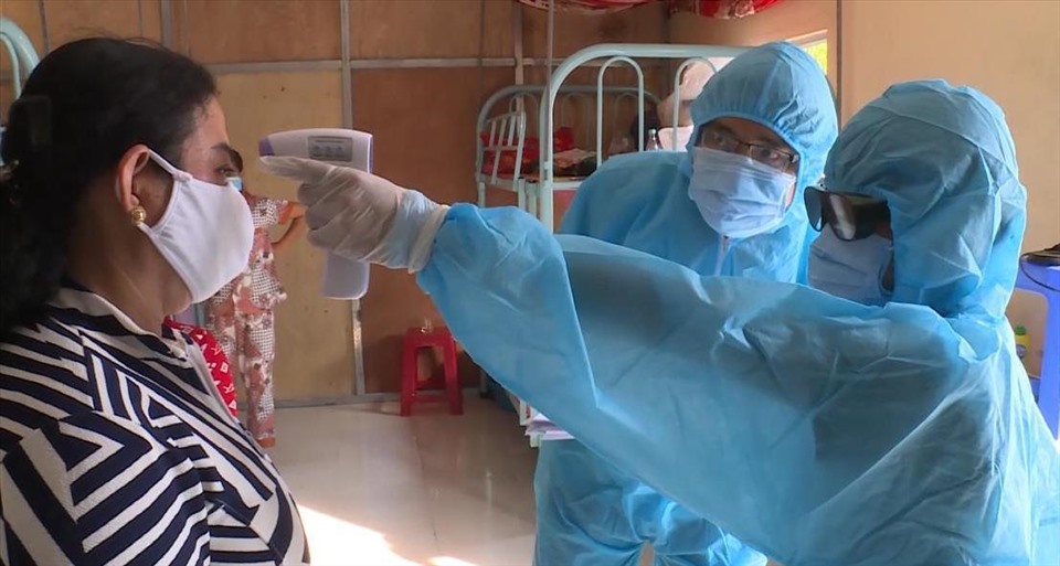 Nhân viên y tế kiểm tra thân nhiệt cho những người ở khu cách ly tập trung ở TP Hà Tiên (Kiên Giang). Ảnh: PV