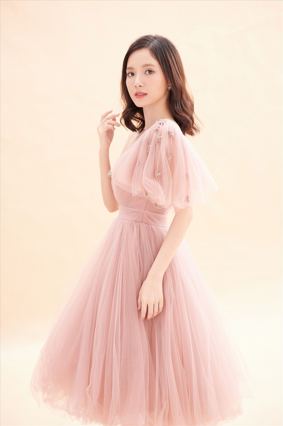 Chiếc váy đầu tiên mang gam màu hồng da trên nền vải voan nhẹ nhàng, tinh tế. Không quá nhiều điểm nhấn nhưng chính sự đơn giản trong outfit còn làm tôn cá tính riêng của người đẹp.