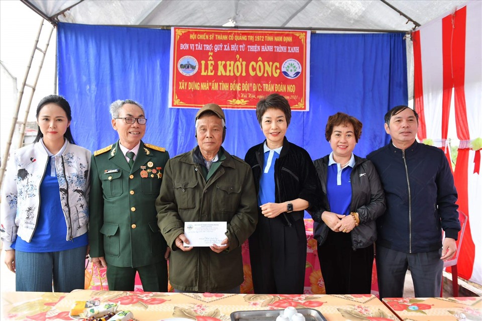 Bà Trần Hải Anh – Chủ tịch Quỹ Hành Trình Xanh (thứ 3 từ bên phải sang) tặng quà tài trợ xây dựng nhà ở cho hai cựu chiến binh. Nguồn: NCB