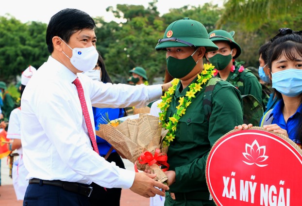Chủ tịch UBND tỉnh Đồng Tháp Phạm Thiện Nghĩa tặng hoa chúc mừng và dặn dò thanh niên nhập ngũ. Ảnh: LT