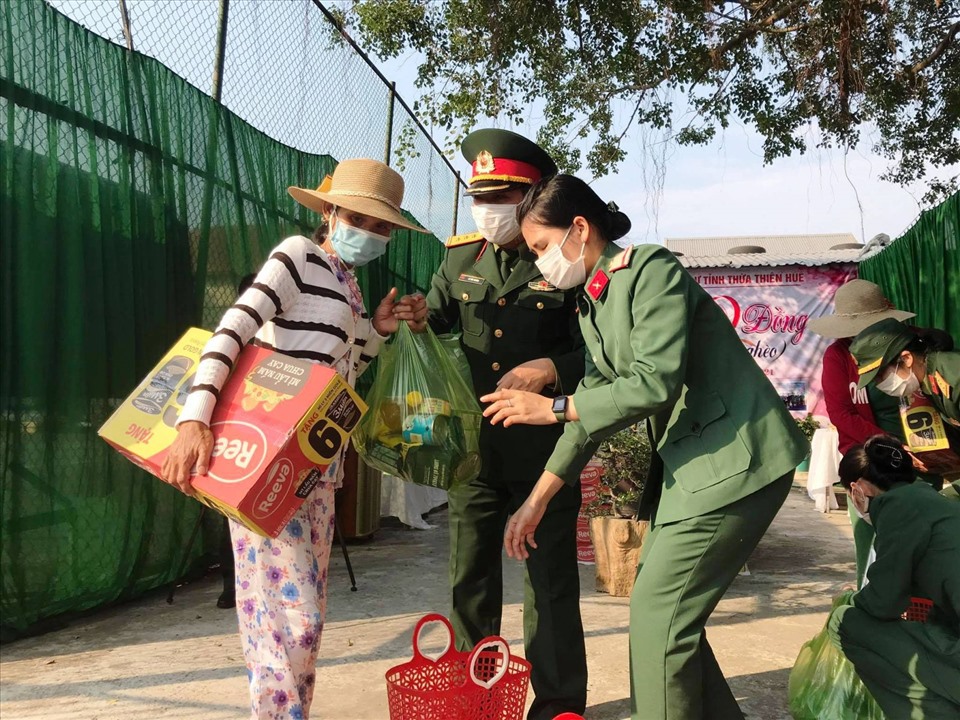 Cán bộ, chiến sĩ hỗ trợ phụ nữ mua hàng 0 đồng. Ảnh: Thanh Thảo.