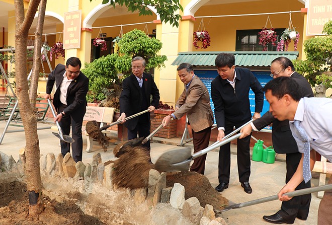 Đồng chí Trần Quốc Vượng cùng các đại biểu trồng cây lưu niệm tại trường. (Ảnh: BYB)