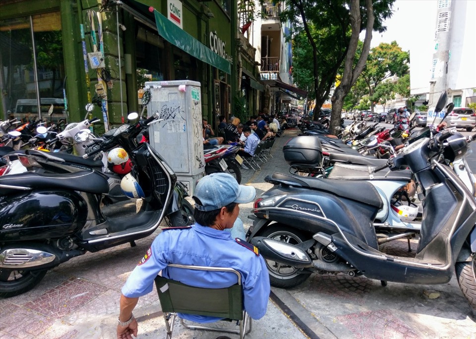 Một quán cà phê trên đường Lê Thị Hồng Gấm (quận 1) bày bàn ghế ra vỉa hè cho khách ngồi và dứng xe máy tràn lan trên vỉa hè.