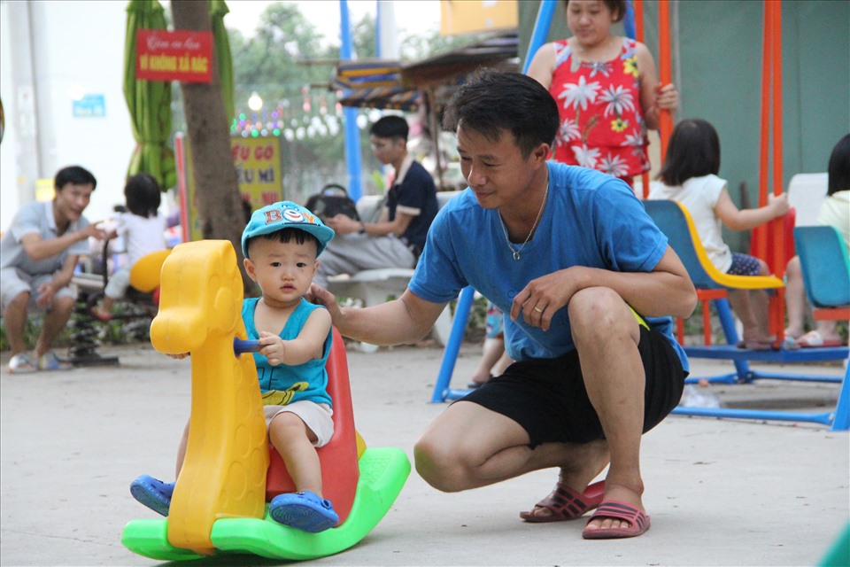 Sau khi tan ca về nhà, anh Võ Văn Chỉnh (30 tuổi) đưa con xuống công viên chơi. Ảnh: Đình Trọng