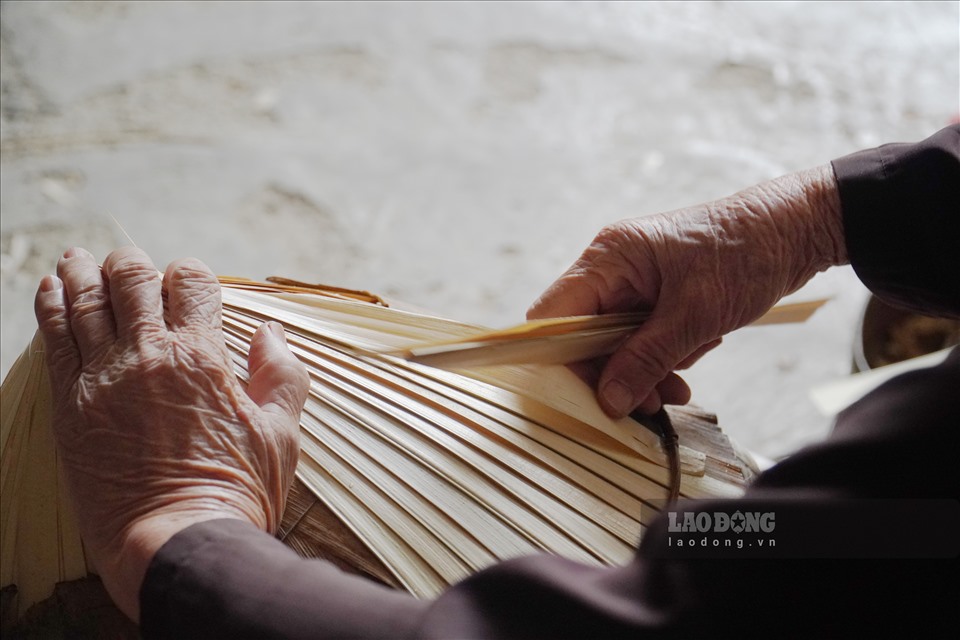 Sau đó đặt một lớp lá lụi, một lớp mo cau, rồi lại một lớp lá lụi. Trong quá trình đặt các lớp lá này cần cố định nón bằng cách buộc chéo những sợi dây dù.