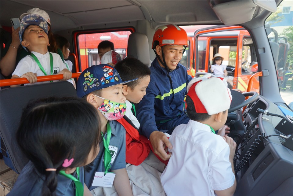 Các em học sinh được đưa lên xe chuyên dụng tham gia vào việc chữa cháy.