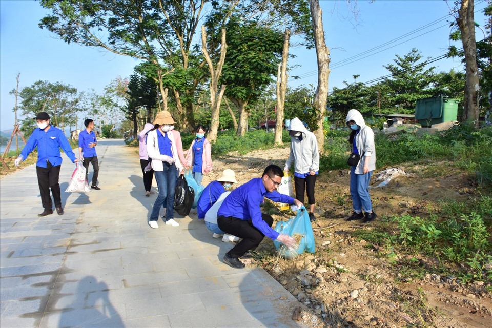 Đoàn viên thanh niên Văn phòng UBND tỉnh dọn dẹp vệ sinh dọc tuyến đường đi bộ bên bờ sông Hương. Ảnh: Ngọc Minh.
