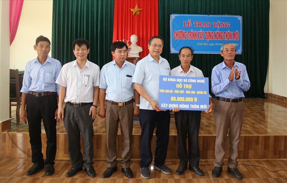 Lãnh đạo Công đoàn Bộ Khoa học và Công nghệ trao tiền hỗ trợ cho người dân thôn Linh Hải. Ảnh: Hưng Thơ.
