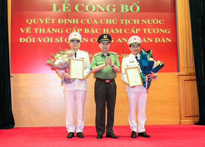 Thừa ủy quyền của Chủ tịch nước, Bộ trưởng Tô Lâm trao Quyết định và tặng hoa chúc mừng Trung tướng Tô Ân Xô và Trung tướng Nguyễn Ngọc Toàn. Ảnh CAND