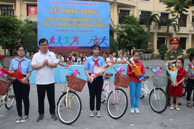 Lãnh đạo UBND TP. Huế và Công an TP. Huế tặng xe đạp cho các học sinh nghèo học giỏi. Ảnh: CA.