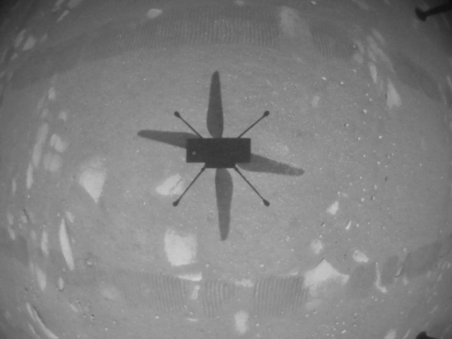 Bóng của trực thăng sao Hỏa Ingenuity trên bề mặt hành tinh đỏ trong chuyến bay đầu tiên ngày 19.4. Ảnh: NASA.