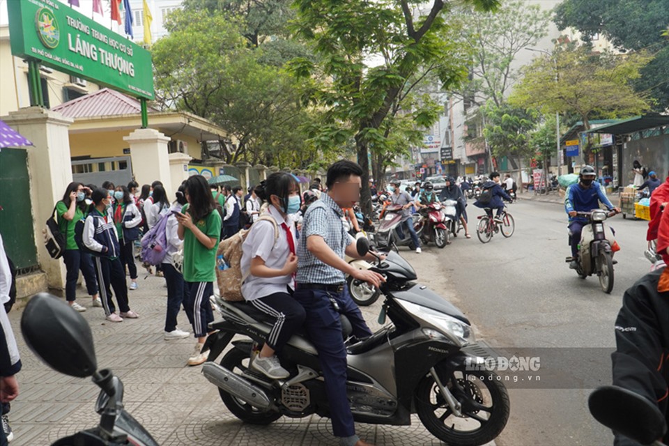 Tại một trường THCS trên phố Chùa Láng (quận Đống Đa), nhiều phụ huynh “quên” nhắc nhở con em mình đội mũ bảo hiểm.
