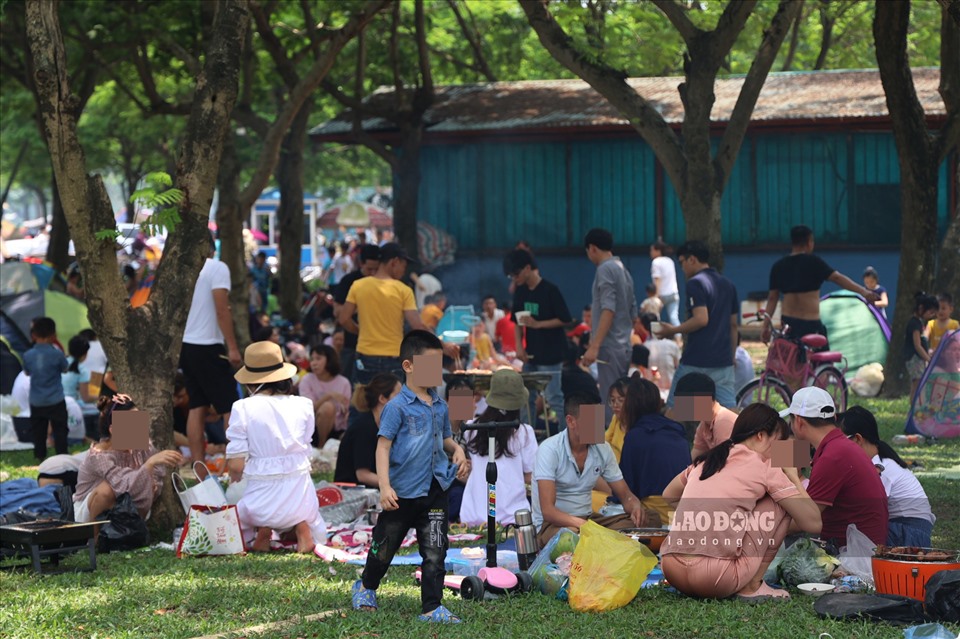 Lượng khách đổ về càng ngày càng đông, nhiều gia đình tận dụng bãi cỏ trống ngồi nghỉ ngơi.