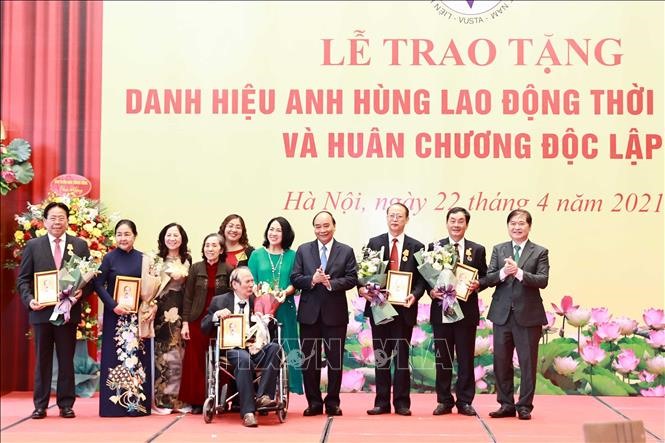 Chủ tịch Nước Nguyễn Xuân Phúc tặng chân dung Chủ tịch Hồ Chí Minh cho đại diện gia đình và các cá nhân tại buổi lễ. Ảnh: Thống Nhất/TTXVN.