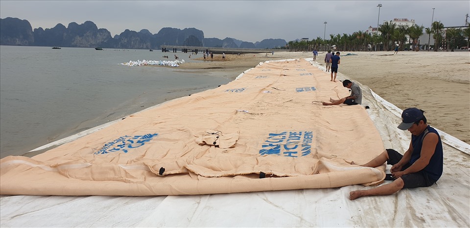 Chuẩn bị đặt đê cát ở phía ngoài biển để chặn cát trôi từ bãi tắm ra ngoài biển. Ảnh: Nguyễn Hùng