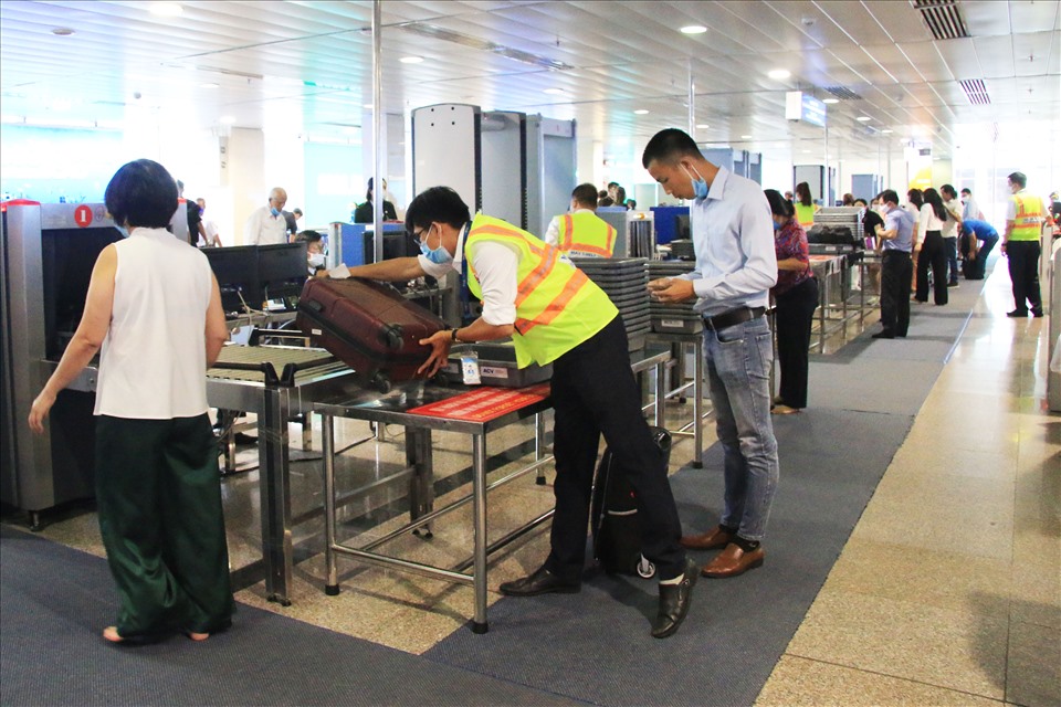 Thanh niên tình nguyện giúp đỡ hành khách tại cổng kiểm tra an ninh.