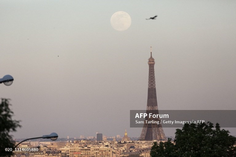 Siêu trăng mọc trên tháp Eiffel, Pháp. Ảnh: AFP