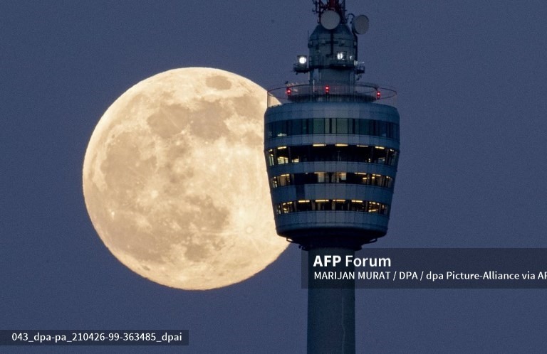 Trăng tròn mọc sau tháp truyền hình Stuttgart, Đức. Ảnh: AFP