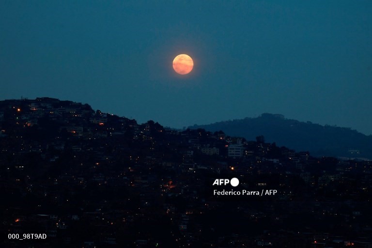 Siêu trăng được nhìn thấy trên khu phố Petare ở Caracas, Venezuela. Ảnh: AFP