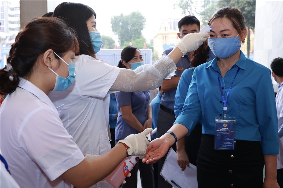 Đại biểu đến dự Lễ kỷ niệm tiến hành khai báo y tế và sát khuẩn phòng chống COVID-19. Ảnh: Hải Nguyễn