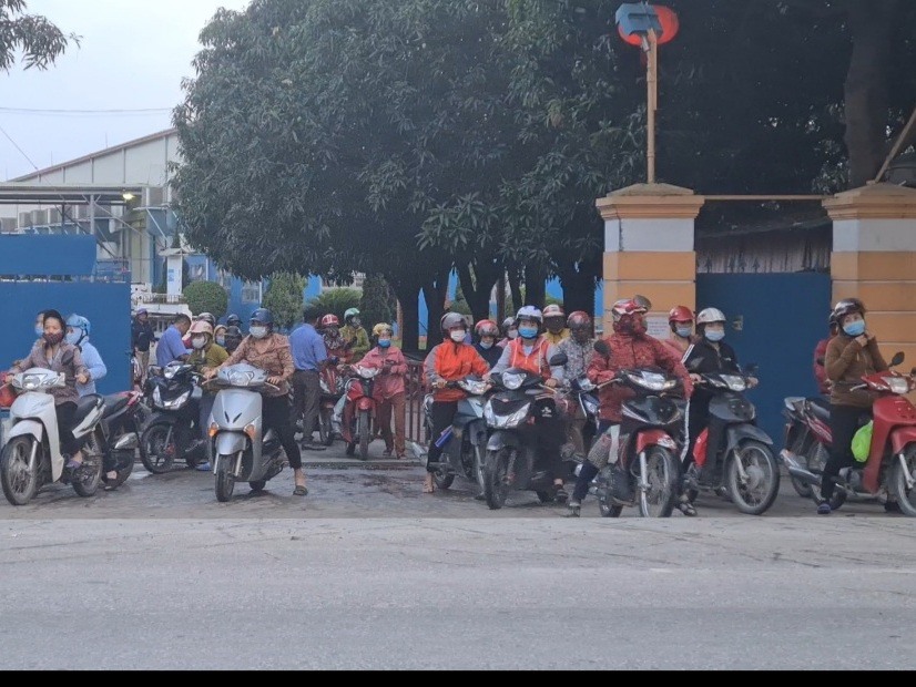 Ngay tại cổng Công ty may Minh Anh - Kim Liên luôn có 2 đến 3 nhân viên bảo vệ đứng kiểm tra công nhân đeo khẩu trang lúc ra về. Ảnh: Quỳnh Trang