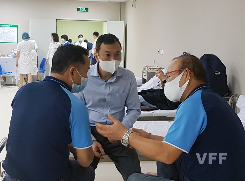 Phó chủ tịch thường trực VFF Trần Quốc Tuấn (giữa) trao đổi công việc với ông Park tại phòng theo dõi sức khỏe sau khi tiêm phòng. Ảnh: VFF