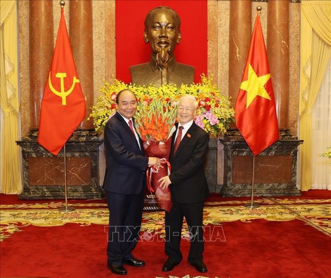 Chủ tịch Nước Nguyễn Xuân Phúc tặng hoa Tổng Bí thư Nguyễn Phú Trọng, nguyên Chủ tịch nước. Ảnh: Trí Dũng/TTXVN