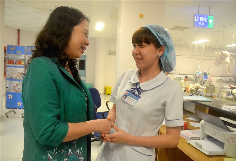 Bà Võ Thị Ánh Xuân “tay bắt, mặt mừng” với nữ nhân viên y tế làm nhiệm vụ trực cấp cứu đêm giao thừa. Ảnh: Lục Tùng