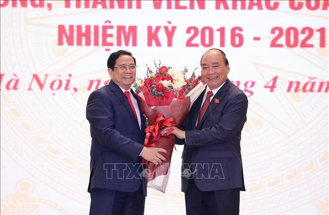 Thủ tướng Phạm Minh Chính tặng hoa chúc mừng Chủ tịch Nước Nguyễn Xuân Phúc. Ảnh: Dương Giang/TTXVN