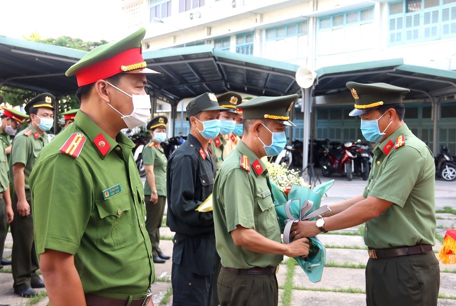 Đại tá Nguyễn Nhật Trường - Phó Giám đốc Công an tỉnh An Giang tặng hoa cho đại diện lực lượng tình nguyện tham gia phòng chống COVID-19 lần thứ 5.2021. Ảnh: Vũ Tiến