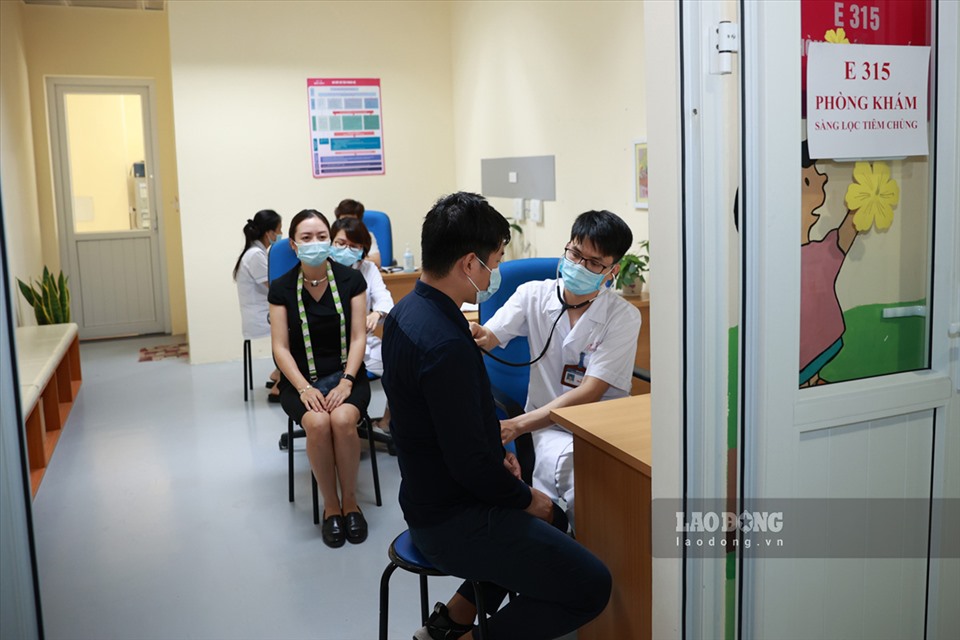Bác sĩ khám sàng lọc cho những người đến tiêm phòng vaccine COVID-19. Ảnh: Hải Nguyễn