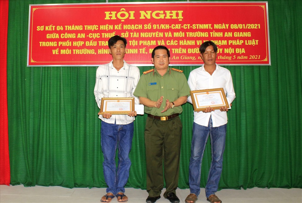 Đại tá Đinh Văn Nơi, Giám đốc Công an tỉnh An Giang trao thưởng cho 2 người dân tố giác nhập cảnh trái phép. Ảnh: Quỳnh Như