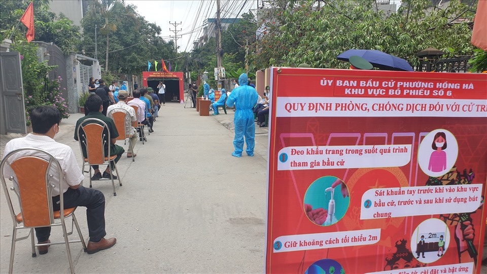 Người dân trong khu bị phong tỏa ngồi xếp hàng chuẩn bị bỏ phiếu. Ảnh: Nguyễn Hùng