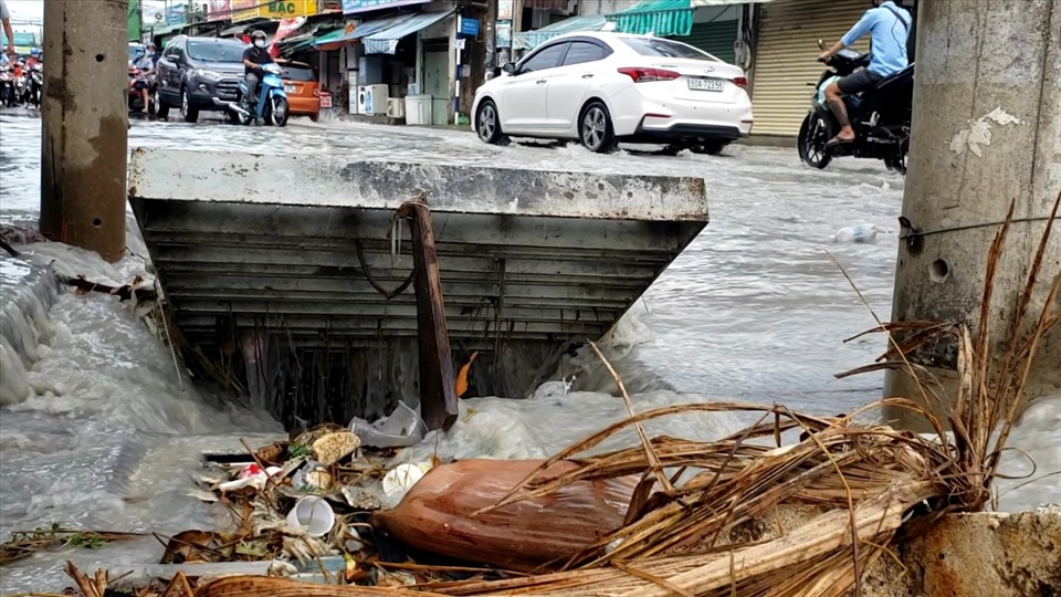 Nắp cống được mở để thoát nước nhưng tiềm ẩn nguy cơ khi có người lưu thông qua lại. Ảnh: Hà Anh Chiến