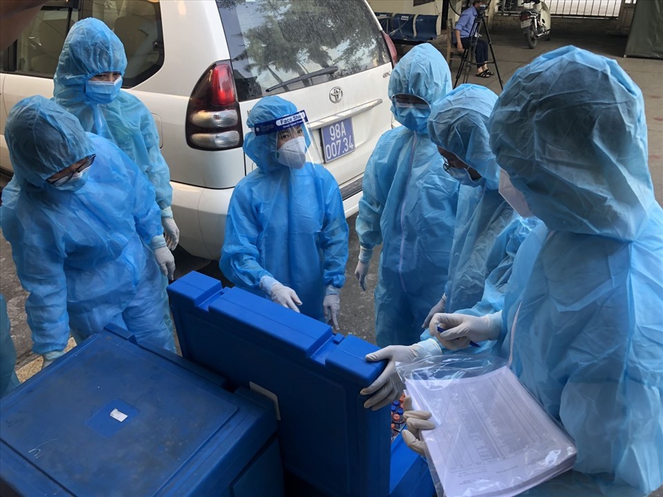 Cán bộ xét nghiệm 2 đơn vị CDC Bắc Giang, Quảng Ninh bàn giao mẫu bệnh phẩm là các F2,F3 tại Bắc Giang. Ảnh: CDC Quảng Ninh