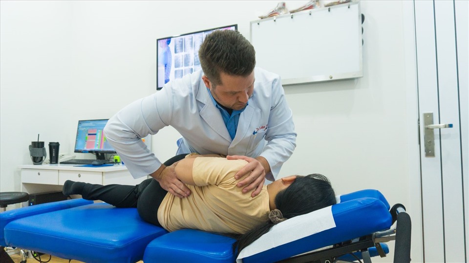 Bác sĩ Luke đang nắn chỉnh cột sống thắt lưng cho bệnh nhân.