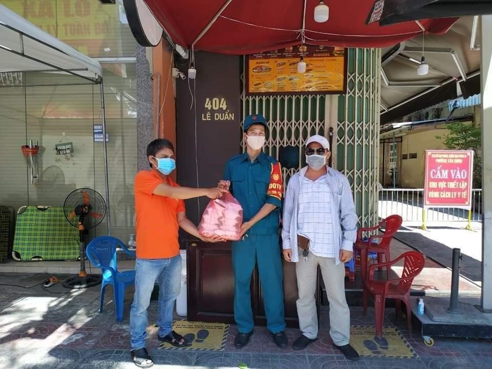 Anh Trần Thịnh Thái (trái) trao bún bò Huế đến lực lượng tuyến đầu chống dịch trên địa bàn thành phố Đà Nẵng. Ảnh: Nhân vật cung cấp
