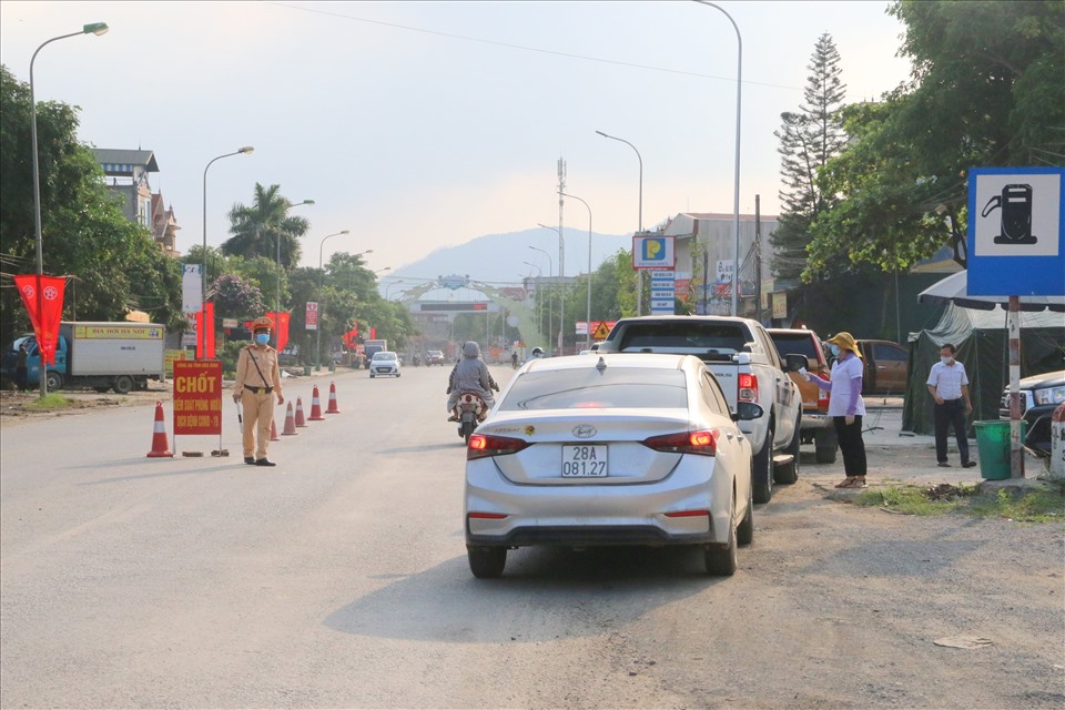 Các phương tiện giao thông đi qua các chốt kiểm soát dịch COVID-19 đều được lực lượng CSGT tiến hành hướng dẫn, khi lái xe đưa xe vào vị trí sát lề đường an toàn, tiến hành đo thân nhiệt và khai báo y tế. Ảnh: Minh Nguyễn.