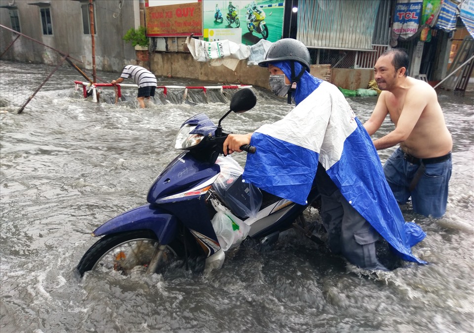 Cư dân hai bên đường liên tục phụ giúp đẩy xe chết máy và hướng dẫn mọi người tìm lối đi khác để tránh bị ngập.