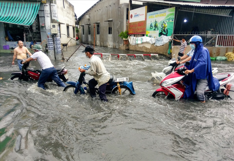 Nước ngập sâu khiến hàng loạt phương tiện chết máy, người dân hì hục đẩy xe về nhà.