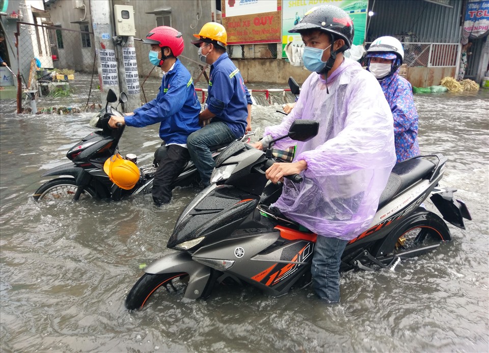 Người dân vất vả di chuyển qua đường ngập.