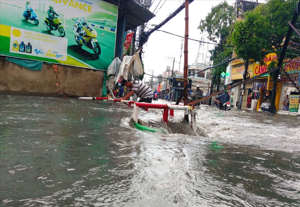 Người dân phải ra bới rác ở mương cho nước mau rút.