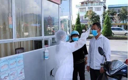 Cán bộ nhân viên y tế của Bệnh viện Đa khoa tỉnh Lai Châu kiểm soát đo thân nhiệt cho người dân trước khi vào khám bệnh. Ảnh: BLC.