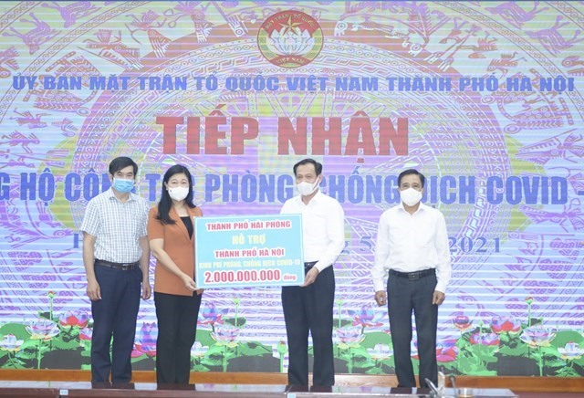 Chủ tịch Ủy ban Mặt trận Tổ quốc thành phố Hà Nội tiếp nhận ủng hộ từ MTTQ thành phố Hải Phòng. Ảnh: N.Phượng