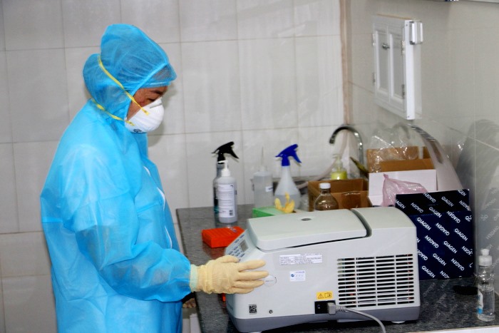 Nhân viên y tế đang thao tác trên thiết bị xét nghiệm SARS-CoV-2. Ảnh: Văn Khương