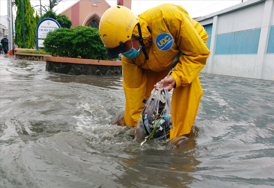Cứ mỗi khi mưa lớn, công nhân công ty thoát nước đô thị lại phải vớt rác tại các miệng cống cho nước thoát nhanh.
