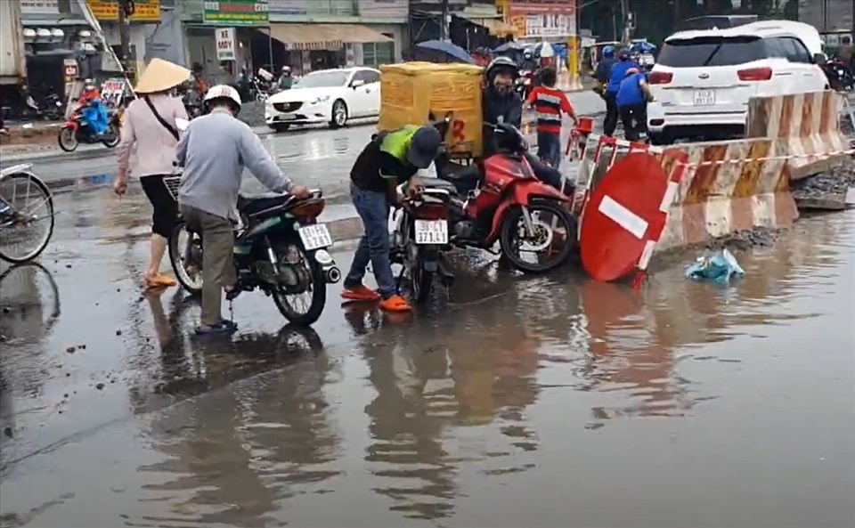 Xe chết máy, nhiều người đi làm về phải đứng đầu đường chờ nước rút mới giám về phòng trọ. Ảnh: Dương Bình