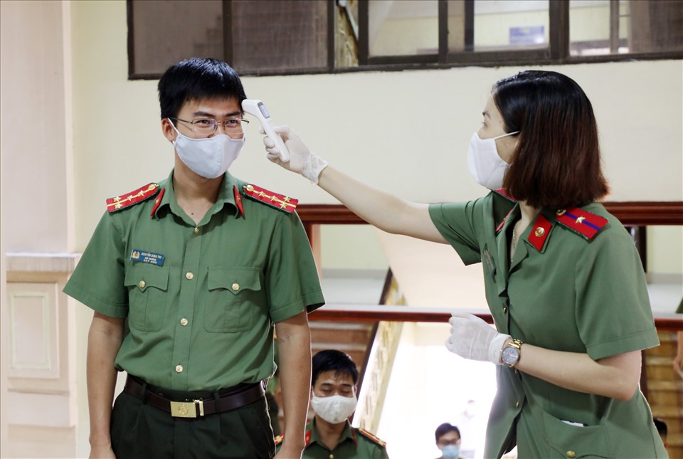 Cử tri Công an tỉnh thực hiện nghiêm việc giãn cách, đo thân nhiệt và sát khuẩn trước khi bầu cử. Ảnh: S.T.